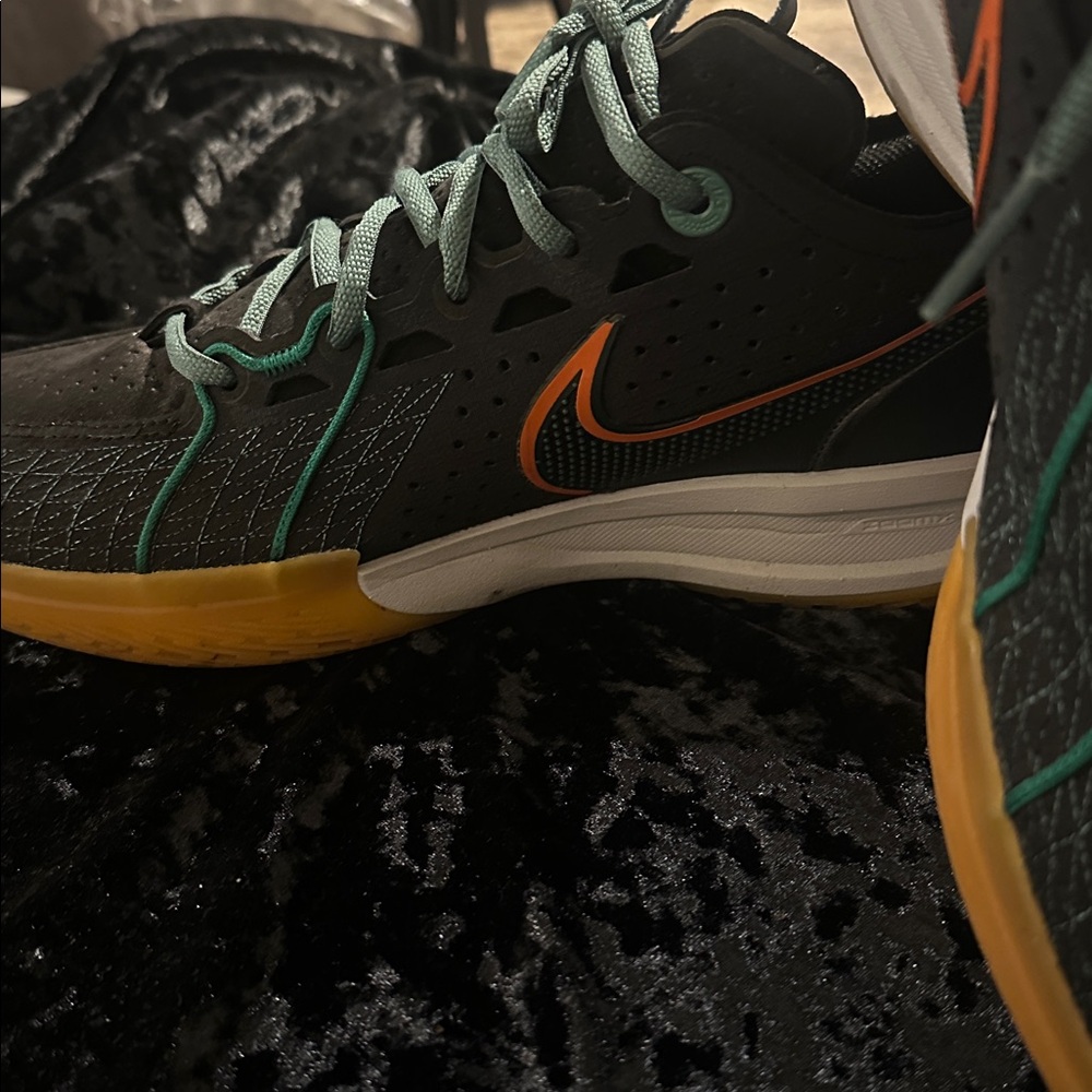 Nike Black and Teal Sneakers with Orange Swoosh
GT.3/CUT
